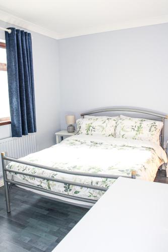 a bed in a white room with a bed frame at The Coach Inn in Strabane