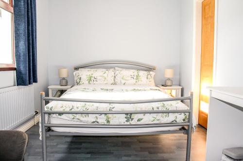 a bedroom with a bed with a white bedspread at The Coach Inn in Strabane