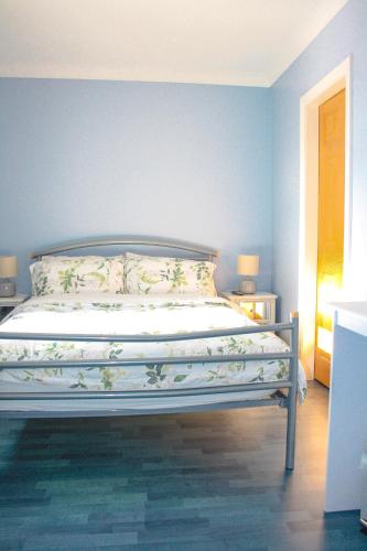 a bed in a bedroom with a blue wall at The Coach Inn in Strabane