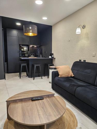 un salon avec un canapé noir et une table dans l'établissement le salon, à Sablons