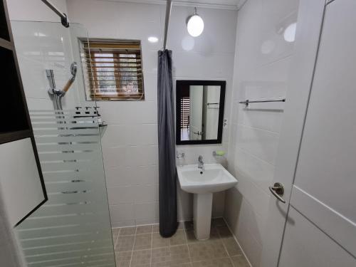 a white bathroom with a sink and a shower at Hazen in Seogwipo