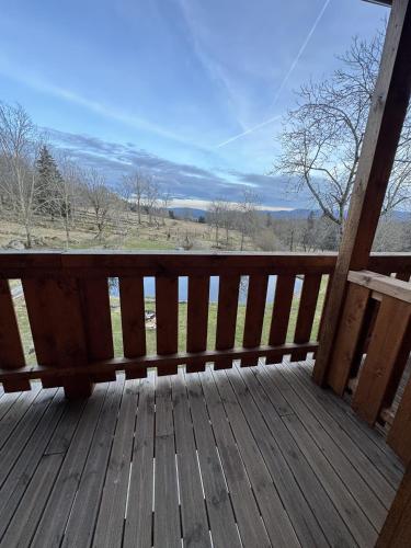 a wooden porch with a view of a field at Penzion Farma Žleby in České Žleby