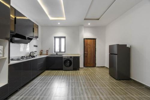 uma cozinha com um frigorífico e uma máquina de lavar e secar roupa em Chuzma Homes em Lagos