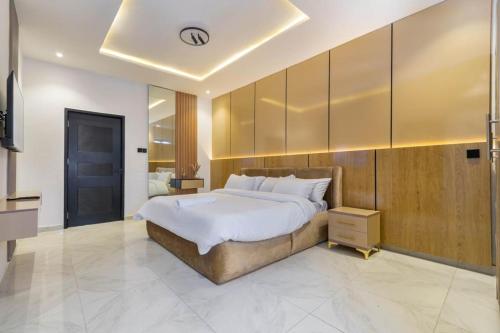 um quarto com uma cama grande e uma parede de madeira em Chuzma Homes em Lagos