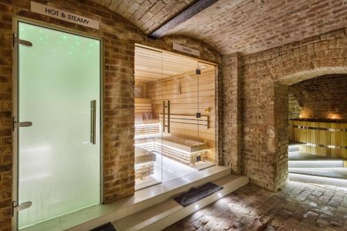 a room with a glass door in a brick wall at Harbour Hotel & Spa Brighton in Brighton & Hove