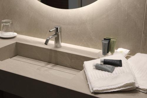 a bathroom sink with a faucet and towels at Relais Le Betulle in Conegliano