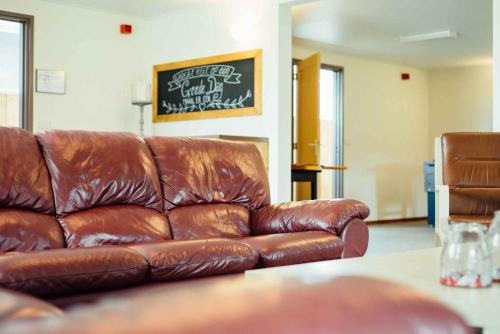 a brown leather couch sitting in a living room at Boertel Lamperse Hei in Wanroij