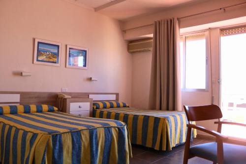 a hotel room with two beds and a window at Bahía - 30º hotels in Puerto de Mazarrón