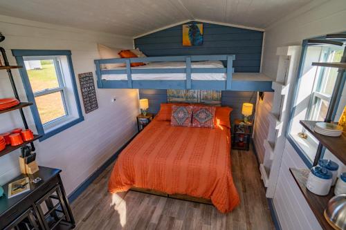 a bedroom with an orange bed in a tiny house at Ravens Rest Retreat 