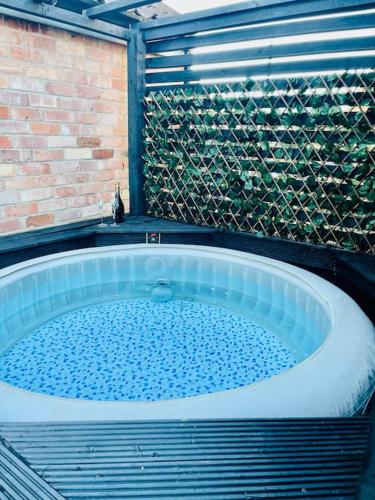 a large tub in a bathroom with a brick wall at East Bridgford Coach House Inc Spa and Treatments in East Bridgford