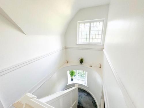 a white staircase with a window in a room at Zen 8-Bedroom Den in Edgbaston in Birmingham