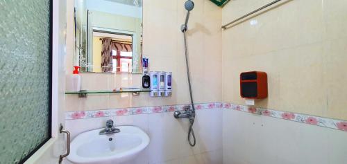 uma casa de banho com um lavatório, um chuveiro e um espelho. em Đăng Dương Motel em Sapa
