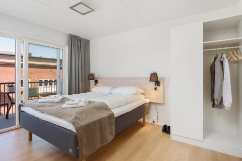 a bedroom with a large bed and a balcony at The Apartments Company - Majorstuen in Oslo