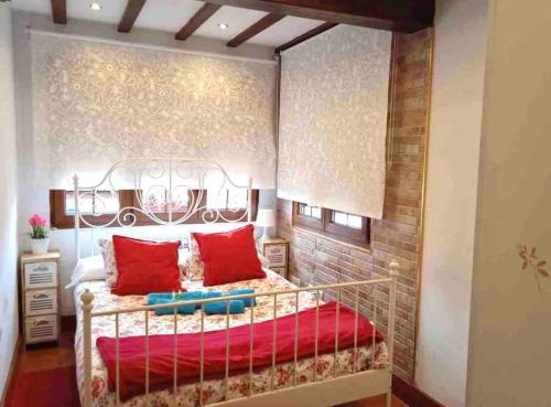 1 dormitorio con 1 cama con almohadas rojas en Casuca Montañesa en Santander, en Santander