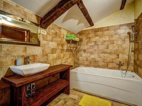 La salle de bains est pourvue d'un lavabo et d'une baignoire. dans l'établissement Holiday House Kapitani, à Hum