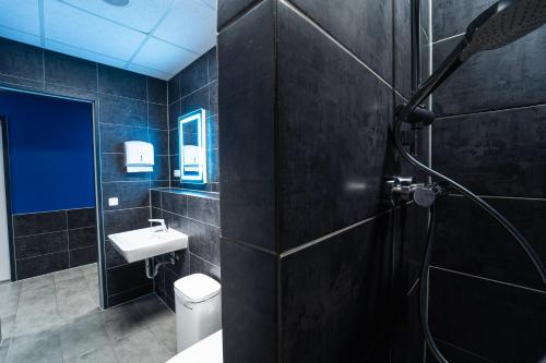 La salle de bains est pourvue de toilettes, d'un lavabo et d'une douche. dans l'établissement Space Night Capsule Hostel, à Berlin