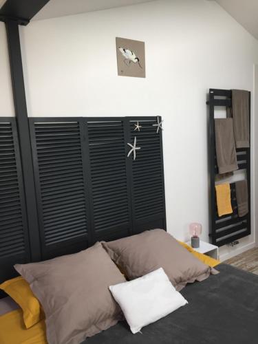 a bedroom with a bed with a black headboard at La Villa Sanson in Arcachon