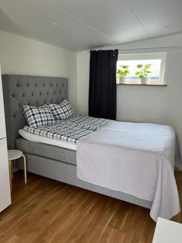 1 dormitorio con 1 cama grande y ventana en Modernt boende med god tillgänglighet. en Alingsås