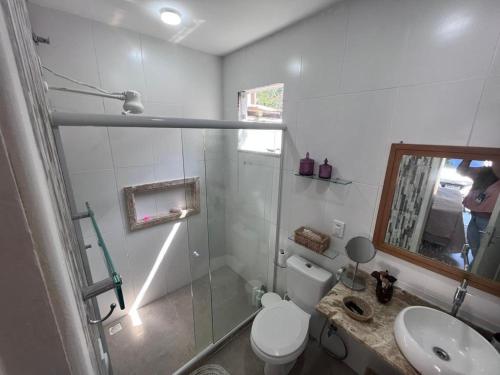 a bathroom with a shower and a toilet and a sink at Casa Recanto de Manguinhos in Búzios