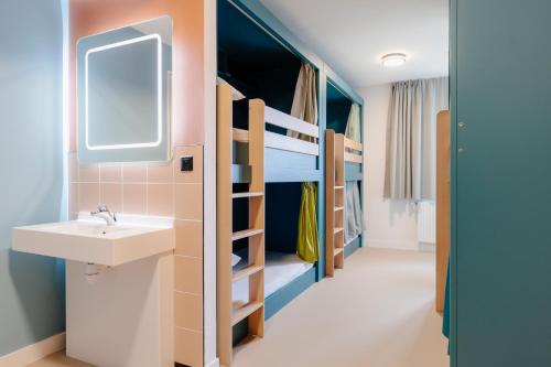 La salle de bains est pourvue d'un lavabo et de lits superposés. dans l'établissement The People Caen, à Caen