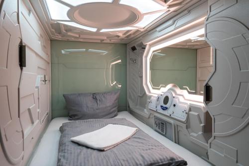 a small room with a bed and a window at Space Night Capsule Hostel in Berlin