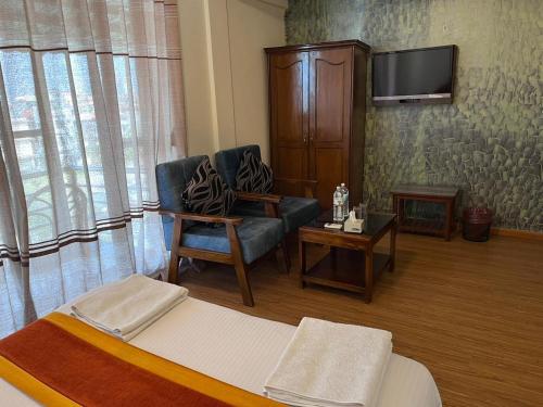 een woonkamer met een bank en een tv bij Hotel Pokhara View backup in Pokhara