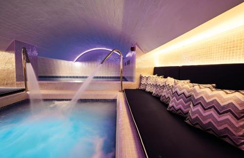 a swimming pool in a room with chairs at Harbour Hotel & Spa Bristol in Bristol