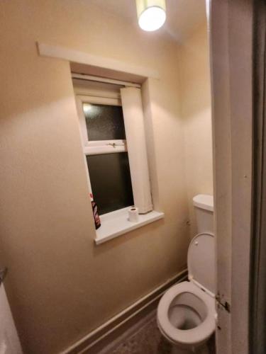 a small bathroom with a toilet and a window at Single Bedroom TDC Greater Manchester in Middleton