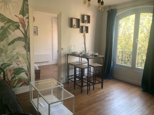 a living room with a table and chairs and a window at Pantin Paris in Pantin