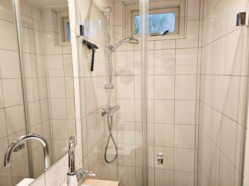 een badkamer met een douche en een glazen deur bij Vakantiewoning in het centrum van Domburg DO29 in Domburg