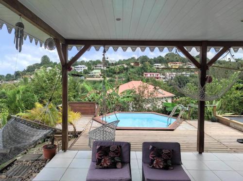 eine Terrasse mit einer Schaukel und einem Pool in der Unterkunft Villa Smile House in Les Trois-Îlets