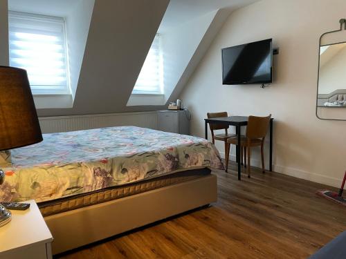 een slaapkamer met een bed en een tafel met een tv bij MG BB in Venlo