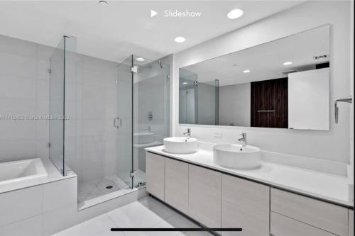 uma casa de banho branca com 2 lavatórios e um espelho em Apartment 3B/3B Stunning view of the intercostal em Hallandale Beach