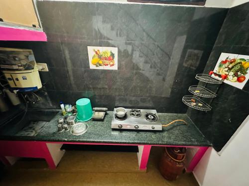 a small kitchen with a table with a stove at Amaravathi Home Stay in Tiruvannāmalai