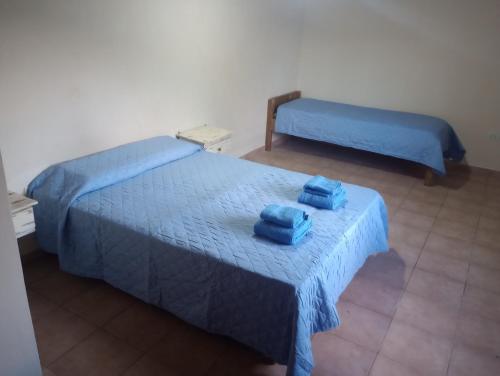 two beds in a room with two blue beds at Cabaña Emilio (El Hoyo) in El Hoyo