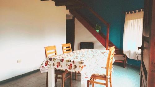 a dining room with a table and chairs and a staircase at Cabaña Emilio (El Hoyo) in El Hoyo