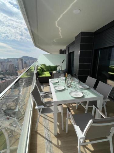 a white dining table and chairs on a balcony at Benidorm Beach Belluba luxury bay in Benidorm