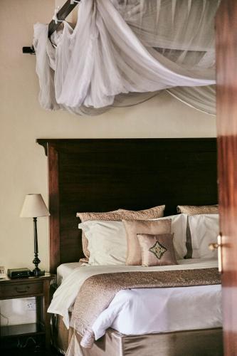 a bedroom with a large bed with a black headboard at Palacina The Residence & The Suites in Nairobi