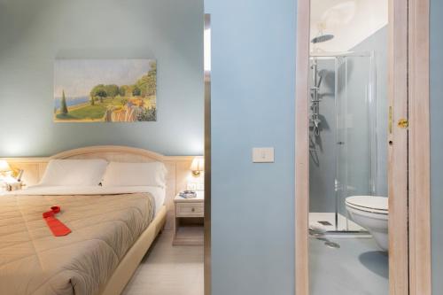 sypialnia z łóżkiem oraz łazienka z toaletą w obiekcie Piccolo Imperiale w Rzymie