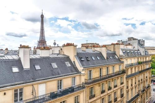 une vue des toits des immeubles avec la tour Eiffel dans l'établissement Chaillot - Lübeck I 1bdr by B'Your Home, à Paris