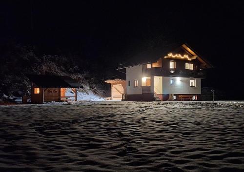 a house with lights on the side of it at night at Chalet Lärchforst in Aich