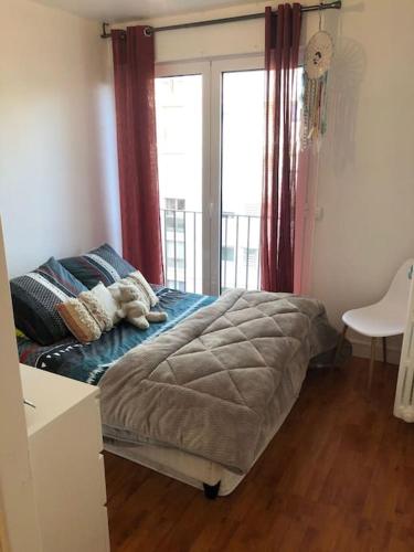 une chambre avec un lit avec une grande fenêtre dans l'établissement Terrasse avec Vue, à Paris