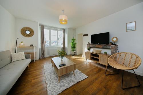 un salon avec un canapé et une télévision dans l'établissement The Bay - Maison au calme à 20min de la plage, à La Haye-Pesnel