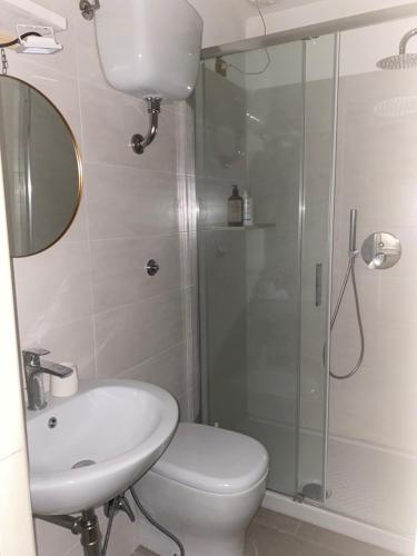 a bathroom with a shower and a toilet and a sink at LE DUNE SUL MARE in Castiglione della Pescaia