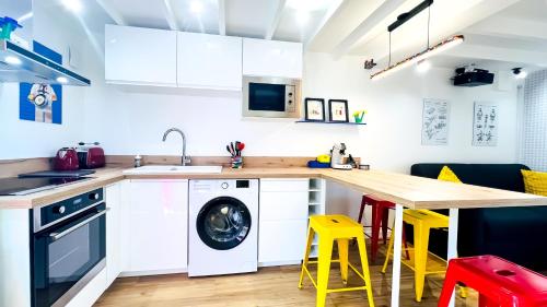 une cuisine avec un comptoir en bois et des tabourets jaunes dans l'établissement Futurostudio - Appart Hôtel LEGO - 5min du Parc Futuroscope - Parking - Poitiers, à Chasseneuil-du-Poitou