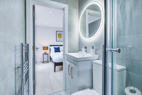 uma casa de banho branca com um lavatório e um espelho em Hybrid Resi - Uxbridge em Uxbridge