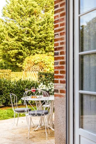 a table and chairs on a patio outside a window at Les Hauts de Loire Relais & Châteaux in Onzain