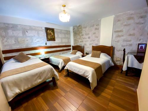 a hotel room with two beds in a room at El Portal De San Lázaro in Arequipa