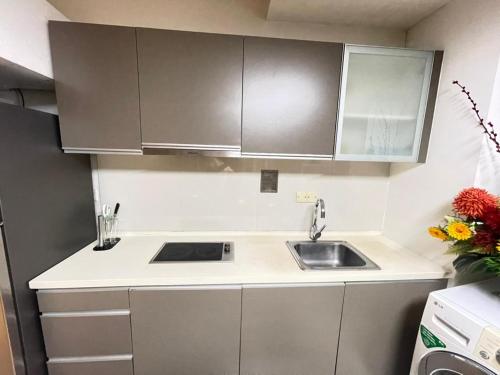 a kitchen with white cabinets and a sink at Regalia Home Stay in Kuala Lumpur