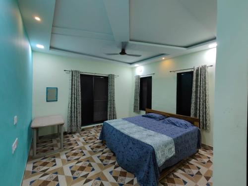 1 dormitorio con 1 cama azul en una habitación con ventanas en R R Villa, en Alibaug